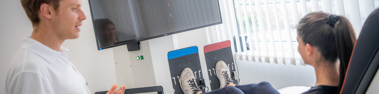 Physiotherapeut instruiert seine Patientin während dem Gleichgewichtstraining am DDrobotec System Elite