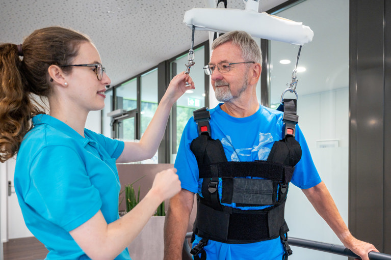 Therapeutin und Patient während der Robotertherapie am C-Mill