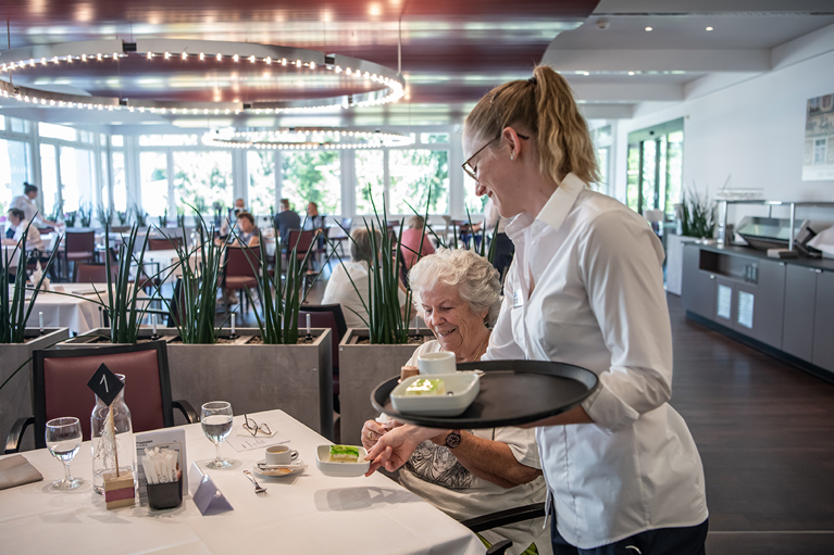 Rehabilitationspatientin beim Mittagessen im Speisesaal der Rehaklinik Dussnang